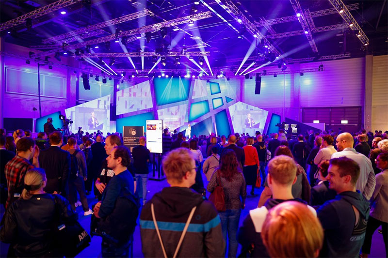 Full exhibition hall with many people in dialogue